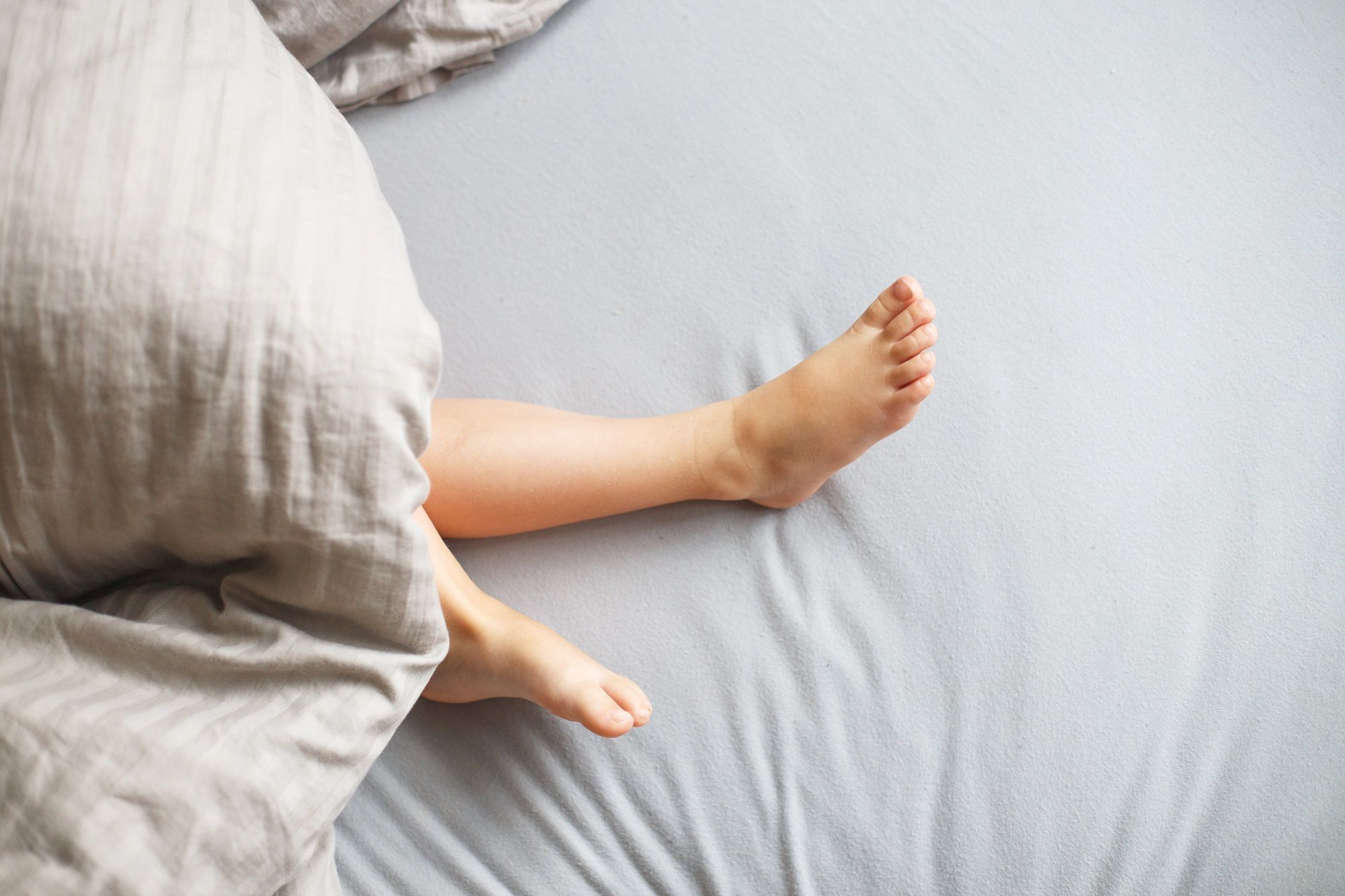 child sleep bed baby s feet stick out from blanket