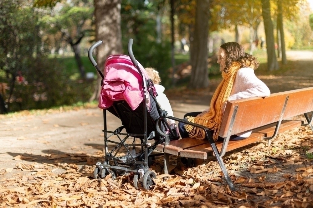 grandmother with baby stroller with granddaughter park