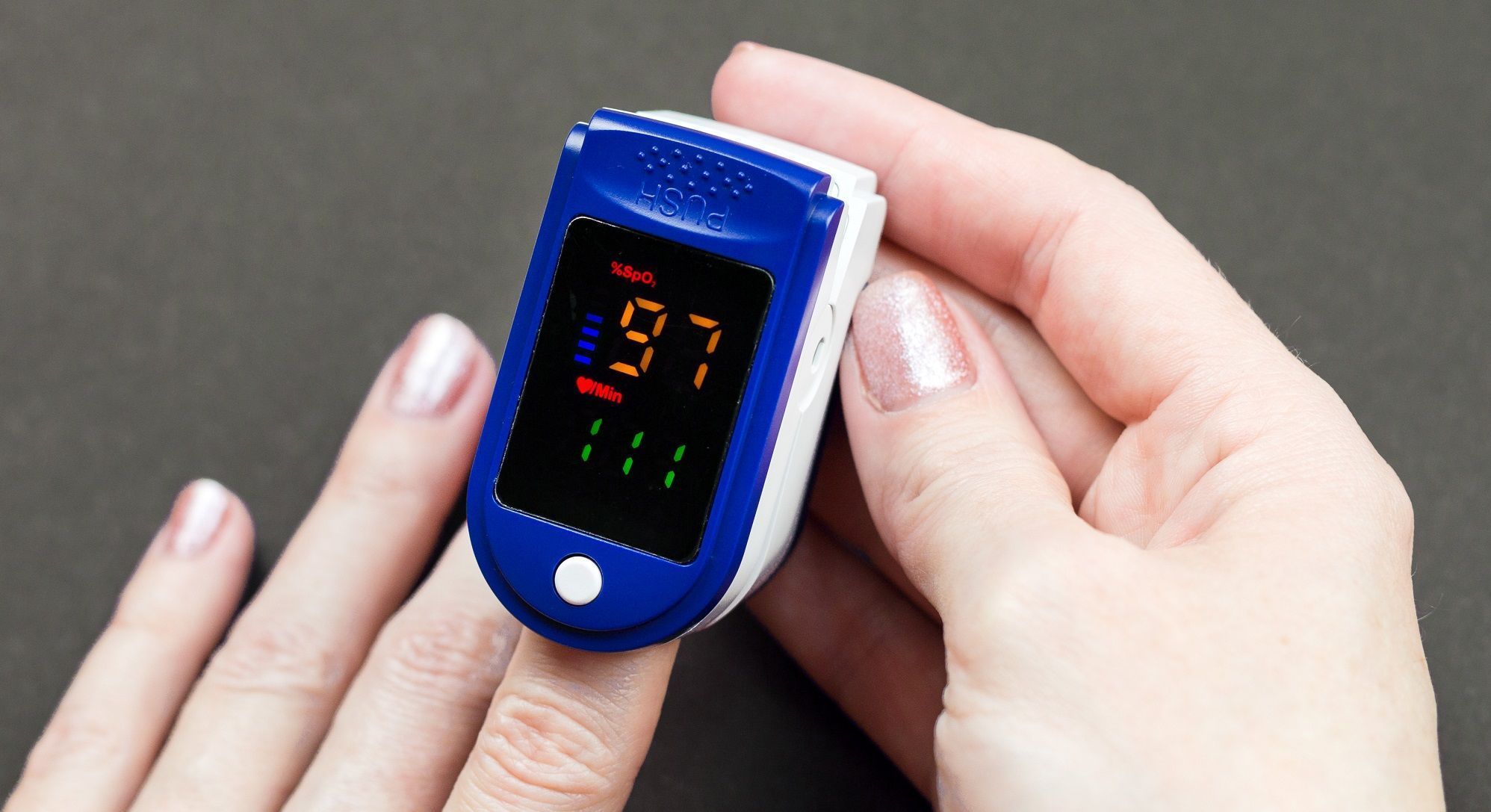 oximeter finger female hand black background