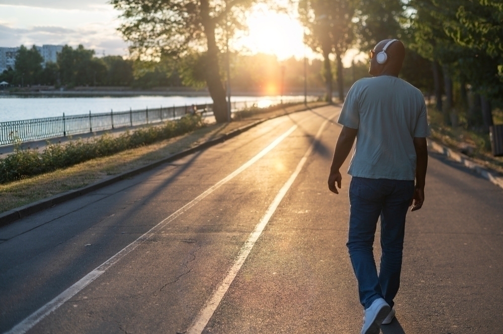 Exterior portrait of black man walking during sunrise