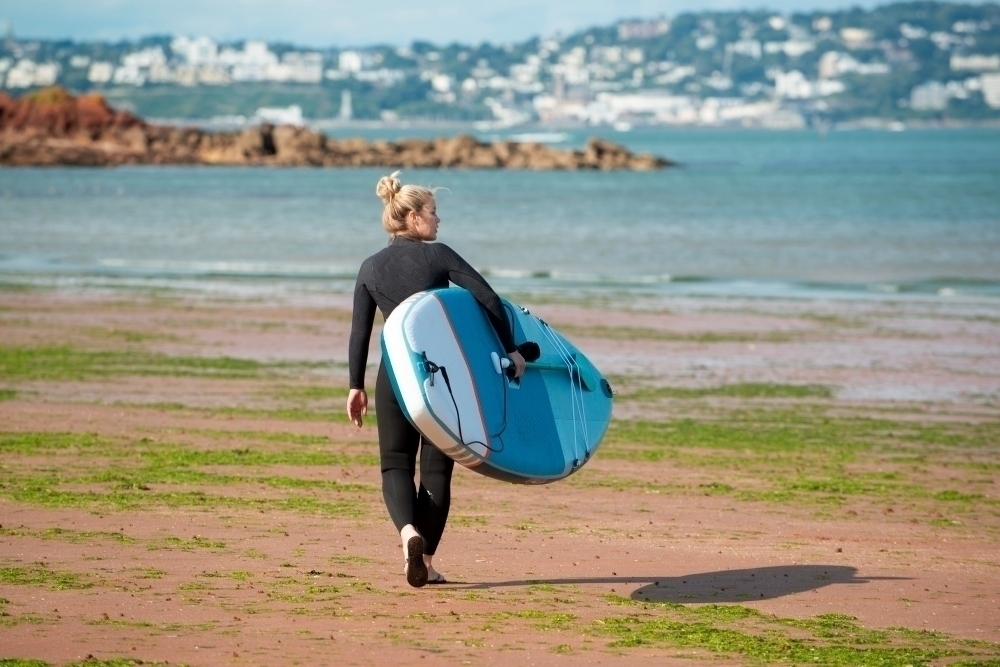 Full shot woman walking with SUP board