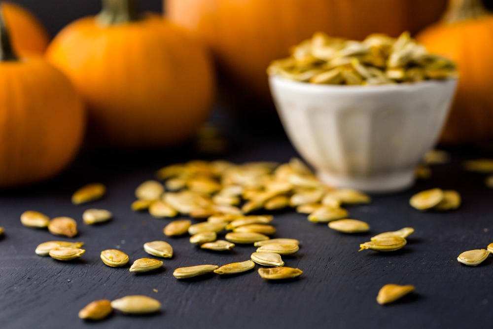 Home cooked pumpkin seeds on black background.
