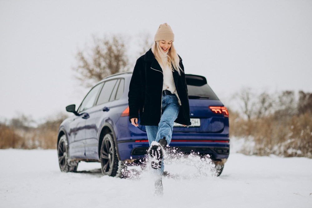 Kvinna vid bilen med vinterdaeck