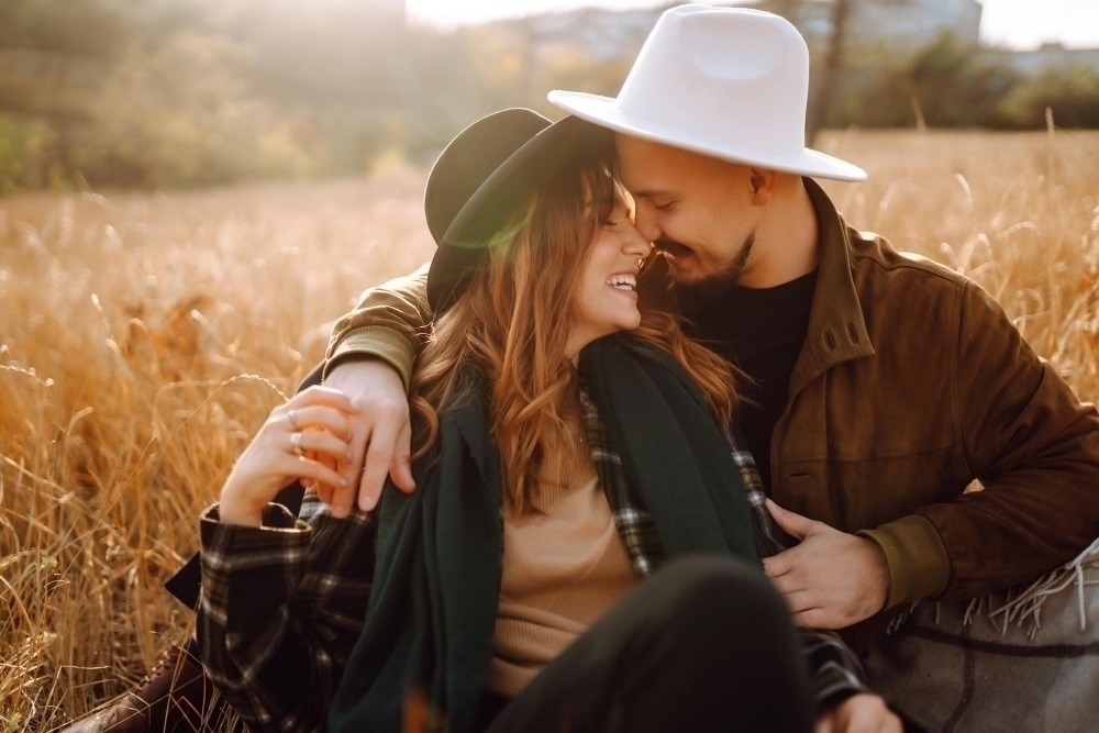 Lovely hipster couple enjoying each other in the autumn park Nice autumn day love and lifestyle