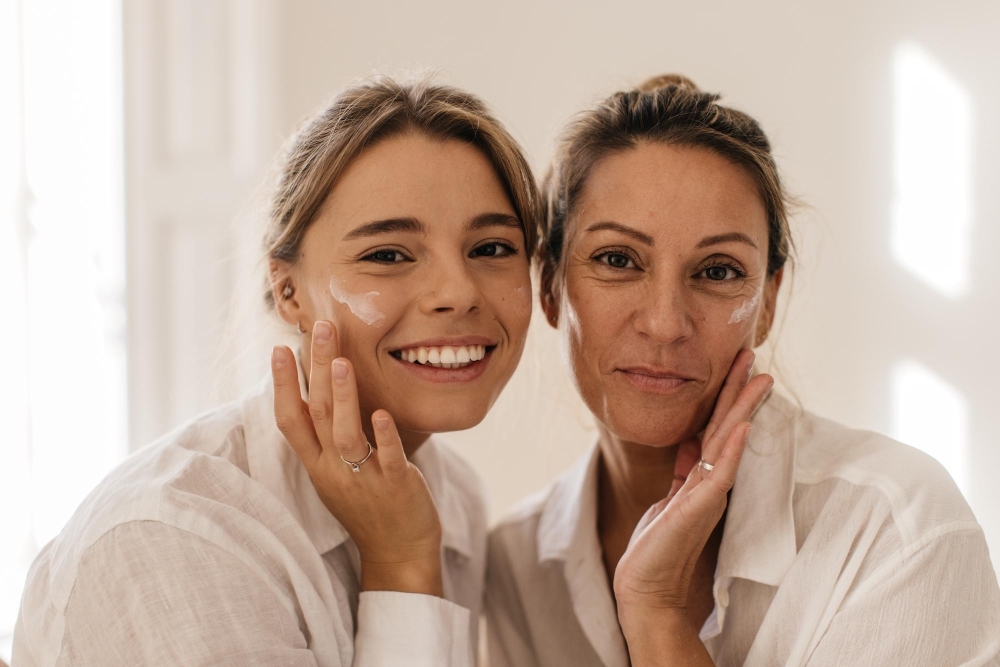 Mor och dotter smoerjer in foundation