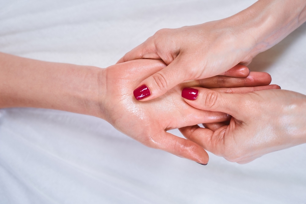 Professional acupressure. professional cosmetologist using body oil while doing massage in salon