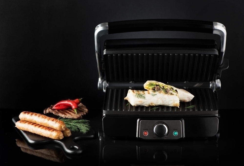 Shawarma sausages and beef steak on an electric grill