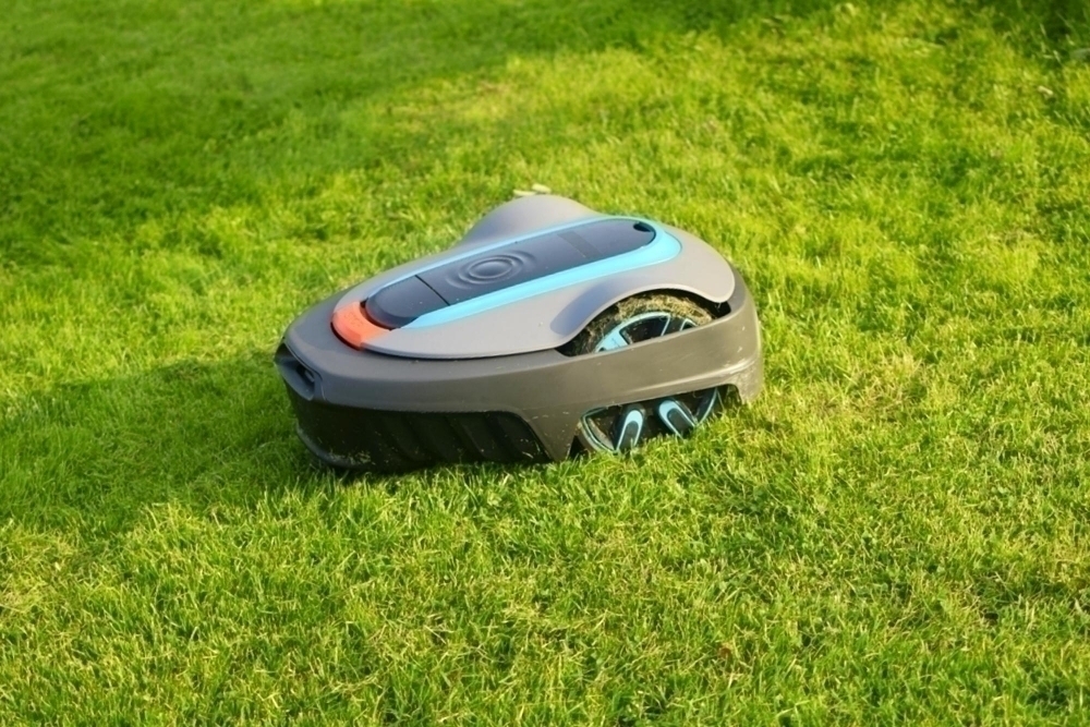 The lawnmower robot mows the glass in the garden