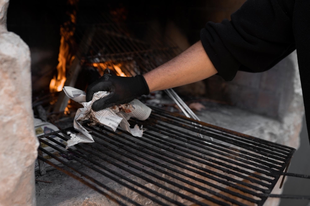 Unrecognizable man cleaning the grill for the barbecue concept of lunch party outdoors