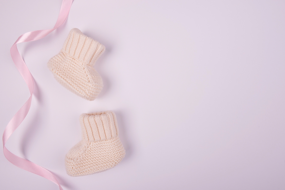 baby socks with pink ribbon flat lay