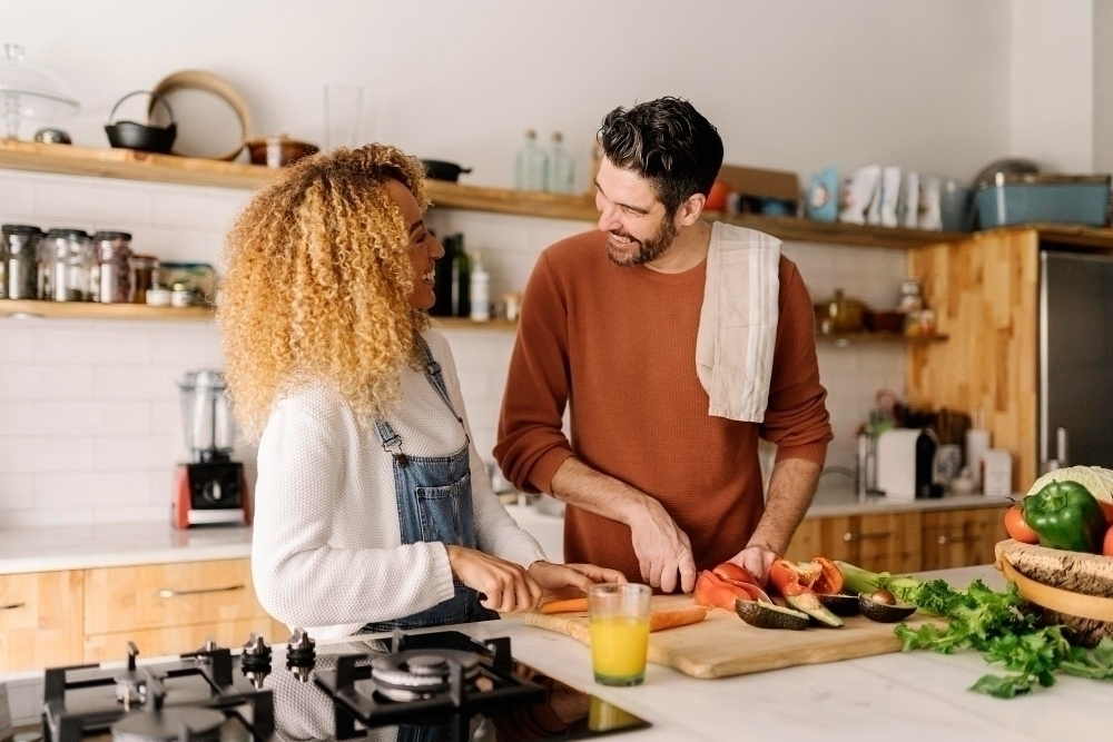 happy couple making dinner together in kitchen