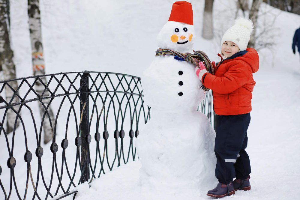 litet barn bygger snogubbe