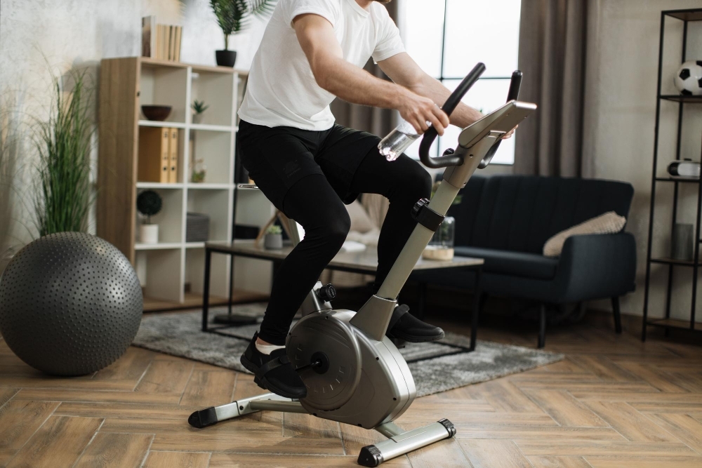 man pa motionscykel i vardagsrum