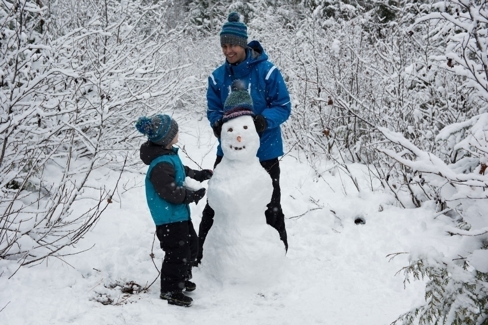 pojke och pappa bygger snogubbe
