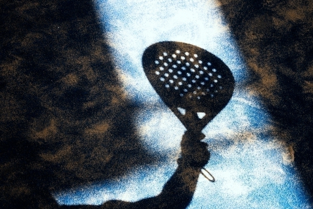 skugga av padelracket pa en padelbana